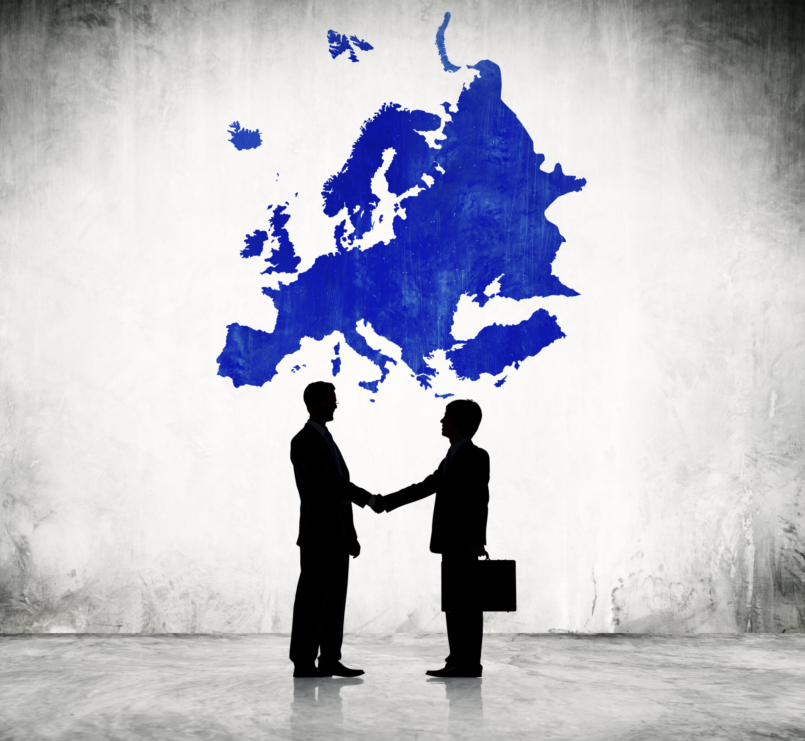 two businessmen shaking hands below a cartography of europe